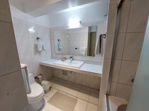 a bathroom with a sink and a toilet and a mirror at Miraflores Pacific Hotel in Lima