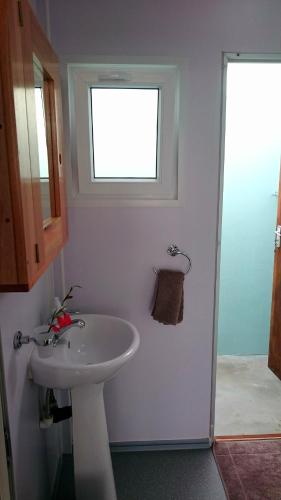 a bathroom with a sink and a window at Shaquila Lodge in Fernão Veloso