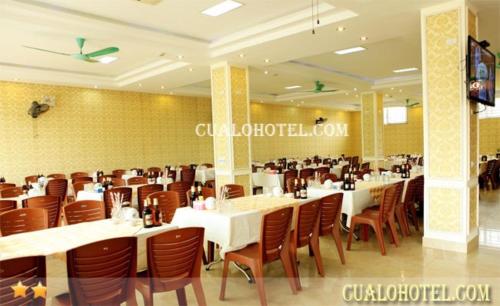 een eetkamer met witte tafels en bruine stoelen bij Trường Sa Hotel Cửa Lò Beach in Cửa Lô