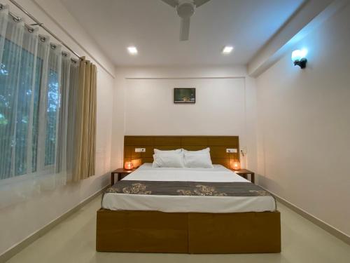 um quarto com uma cama grande e uma janela em Daffodils Luxury Airport Suites em Cochin