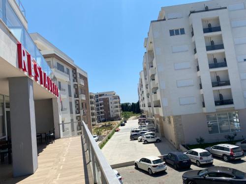 an apartment building with cars parked in a parking lot at Ulcinj Apartments in Ulcinj