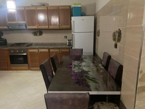 uma cozinha com uma mesa e cadeiras e um frigorífico em Appartement à cape de l’eau en plein centre em Ras El Ma