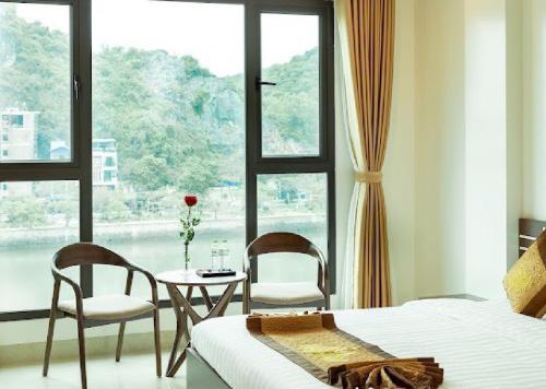a bedroom with a bed and a table and chairs at Tung Quang Hotel in Cat Ba