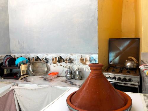 a kitchen with a stove and a vase on a counter at Maison ELS 2 Pièces in Moulay Bousselham