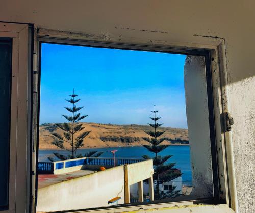 a window with a view of a body of water at Maison ELS 2 Pièces in Moulay Bousselham