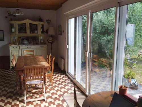 une salle à manger avec une table et une grande fenêtre dans l'établissement Maison cosy 6 pers, plage à 160m, jardin clos, plancha, ménage inclus - FR-1-224B-204, à Noirmoutier-en-l'lle