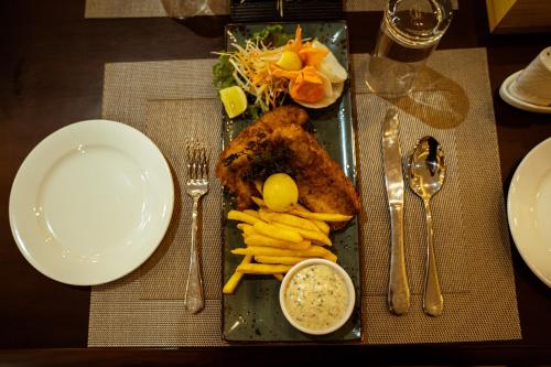 a plate of food with chicken and french fries on a table at Hotel Black Diamond - Transit Point Inside Hotel in Kathmandu
