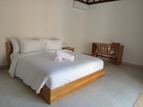 a bedroom with a bed with two towels on it at Villa Penyu Gili Trawangan in Gili Trawangan
