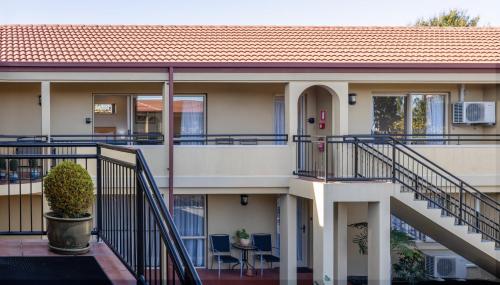 a building with stairs and a table and chairs at Lorenzo Motor Lodge in Christchurch