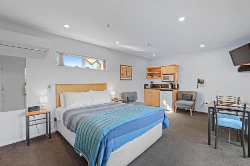a hotel room with a bed and a kitchen at Lorenzo Motor Lodge in Christchurch