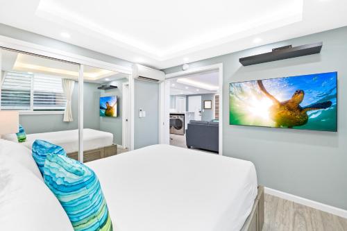 a bedroom with a bed and a tv on a wall at Fully Renovated 2BR and 2BA Near Waikiki Beach with Parking in Honolulu