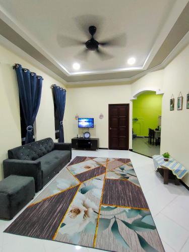 a living room with a couch and a ceiling fan at Raihan Homestay Kubang Kerian, Free Wifi in Kota Bharu