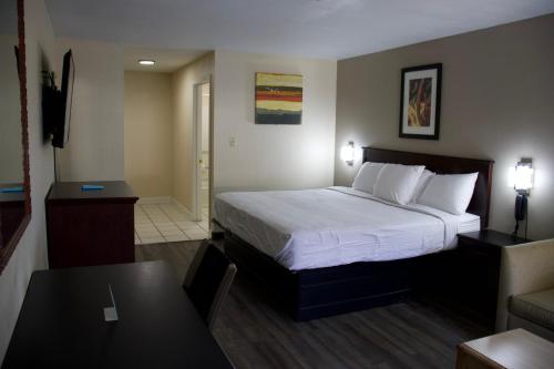 um quarto de hotel com uma cama e uma sala de estar em Legacy Inn - Cookeville em Cookeville