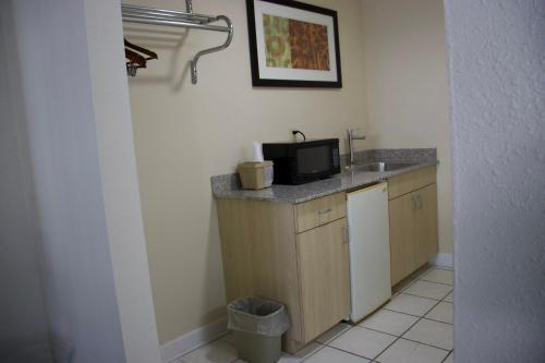 Una pequeña cocina con fregadero y microondas. en Legacy Inn - Cookeville, en Cookeville