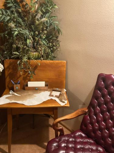una mesa con una silla junto a una mesa con una planta en Yellowstone Cattle Baron EnSuite, Private Entrance & Parking - Prairie Rose B&B, en Cheyenne