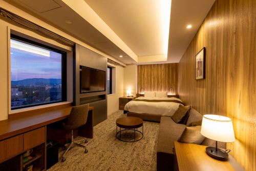 敦賀市にあるホテルグランビナリオ敦賀のベッドとテレビが備わるホテルルームです。