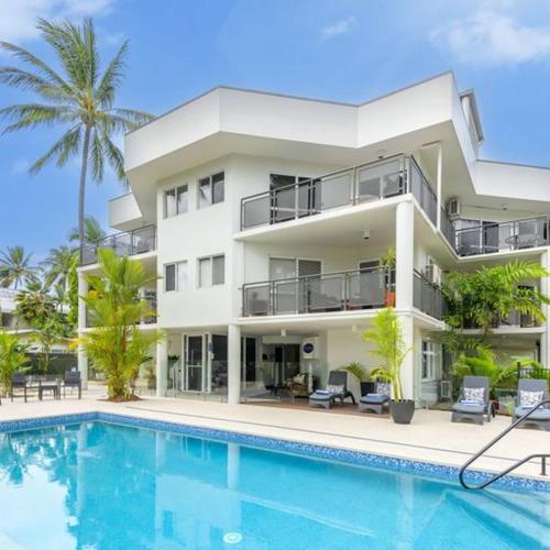 a large white building with a swimming pool in front of it at Marina Terraces Port Douglas in Port Douglas