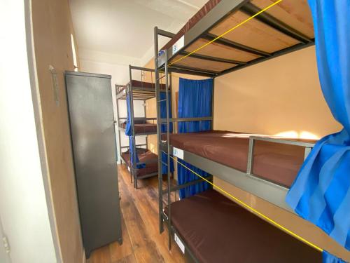a room with two bunk beds with blue curtains at Aurora Hostel Rio in Rio de Janeiro