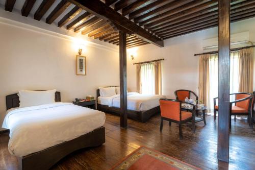 Postel nebo postele na pokoji v ubytování Hukum Darbar Restaurant & Hotel