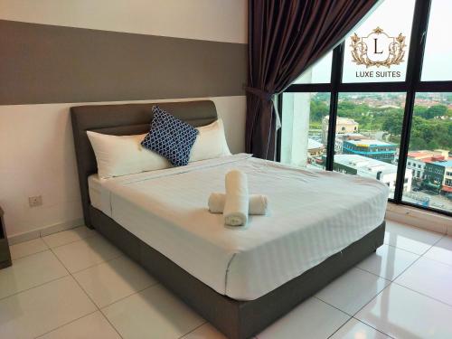 a bedroom with a bed with a teddy bear on it at Luxe Suites at Skyloft in Johor Bahru