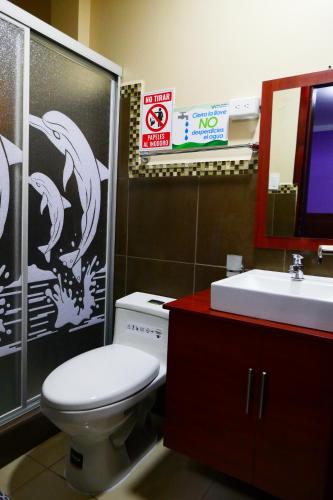 a bathroom with a toilet and a sink at Hostal Valle Andino in El Tambo