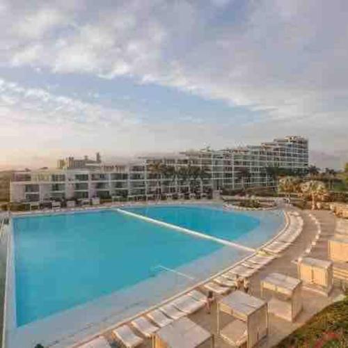 a large swimming pool with a hotel in the background at Paraíso frente al mar 313 in Nuevo Vallarta