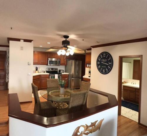 a kitchen with a table and a clock on the wall at Hamilton Cove Panoramic Ocean View Condo #2/32 in Avalon