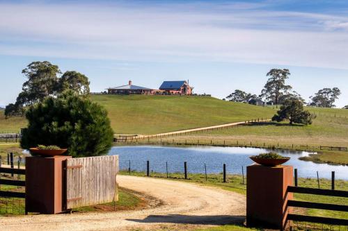 a dirt road leading to a house on a hill with a lake at Villa Monte Lago in Glenlyon