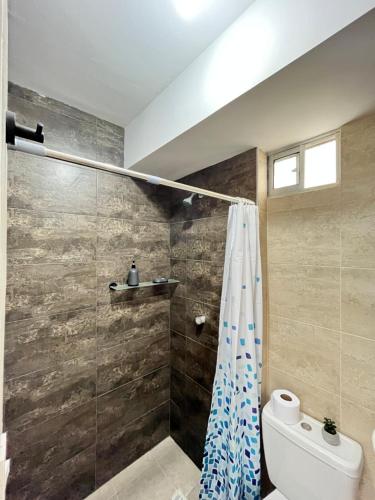 uma casa de banho com uma cortina de chuveiro e um WC em Apartamento 30min del Mar em Cartagena das Índias