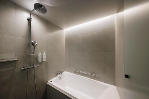a bathroom with a bath tub and a shower at Fairfield by Marriott Hyogo Awaji Higashiura in Awaji