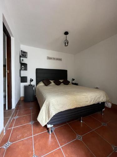 a bedroom with a large bed in a room at Zoola Suites Antigua in Antigua Guatemala