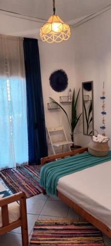 a bedroom with a bed and a chandelier at Mana mia Seaside Apartments in Leptokaria