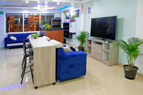 a living room with a blue couch and a tv at Hostal Valle Andino in El Tambo