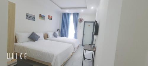 a hotel room with two beds and a television at Ánh Dương Homestay - Coastal stop - Just 2 mins walking to Eo Gio in Quy Nhon