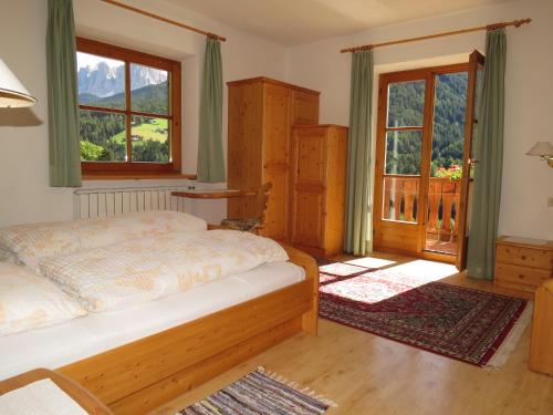 ein Schlafzimmer mit einem Bett und einem großen Fenster in der Unterkunft Agriturismo Kabishof in Villnöss