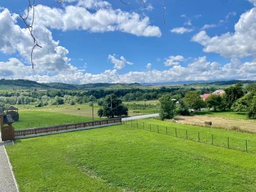 a view of a grassy field with a fence at Pensiunea Sofia in Onceşti