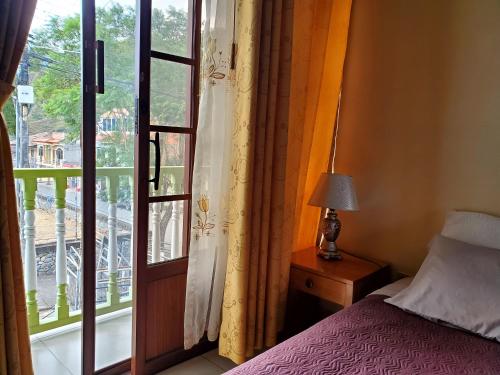 a bedroom with a bed next to a window at In the heart of Vilcabamba. Residence don Tuquito. in Vilcabamba