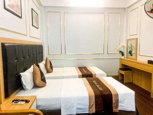 a bedroom with two beds and a table at Hotel Vi&ecirc;̣t Mỹ in Hanoi