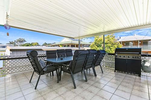 a patio with a table and chairs on a balcony at OceanViews on Burrum Up in Toogoom