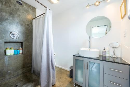 a bathroom with a sink and a shower with a mirror at The Raven House - Renovated Homestead Cabin in Joshua Tree