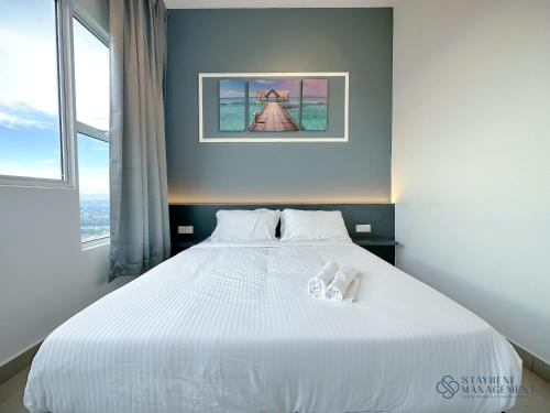 a bedroom with a white bed with white shoes on it at Melaka Novo 8 Residence - Jonker Street by Stayrene in Melaka