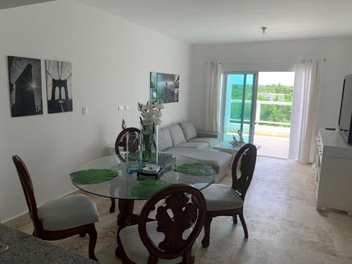 a dining room with a table and chairs and a couch at Apartamento en Playa Nueva Romana in La Romana