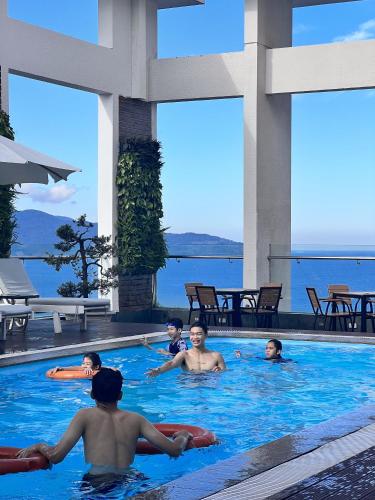 a group of people swimming in a swimming pool at Diamond Sea Hotel in Da Nang