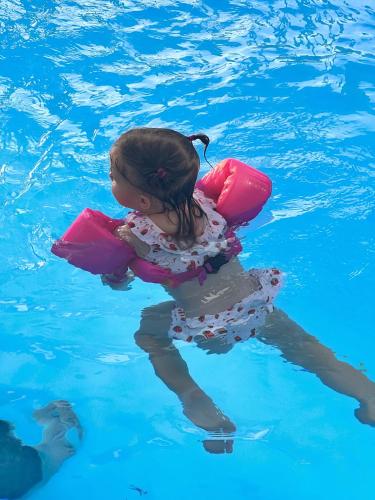 a little girl in a life vest in the water at Diamond Sea Hotel in Da Nang