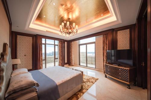 1 dormitorio con 1 cama y TV de pantalla plana en Sheraton Shantou Hotel, en Shantou