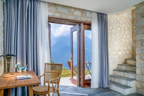 a room with a table and chairs and a window at Topas Ecolodge in Sa Pa