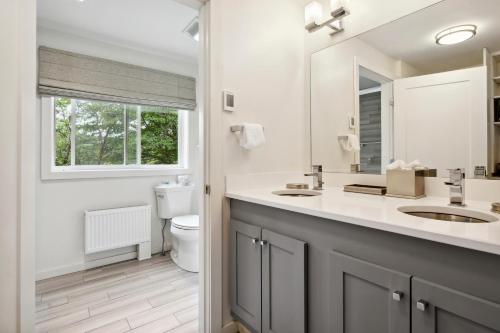 a bathroom with a sink and a toilet and a window at Mountaineer Inn in West Dover