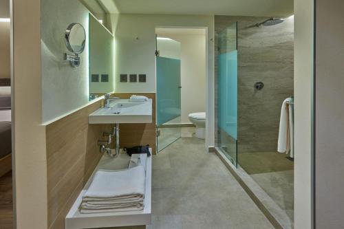 y baño con lavabo y ducha. en City Express Plus by Marriott Mazatlan en Mazatlán
