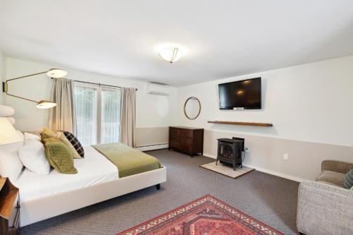a bedroom with a bed and a fireplace and a tv at Mountaineer Inn in West Dover