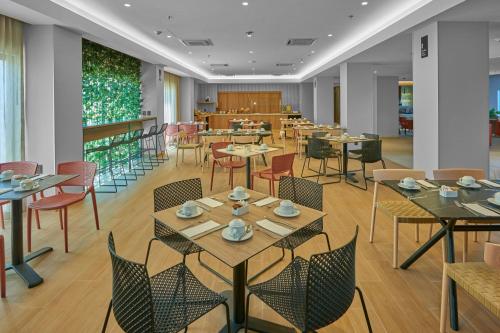 a restaurant with tables and chairs in a room at City Express Plus by Marriott Mazatlan in Mazatlán